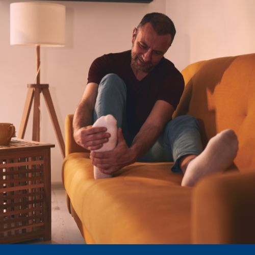 Imagem de homem tocando na perna com lesão.